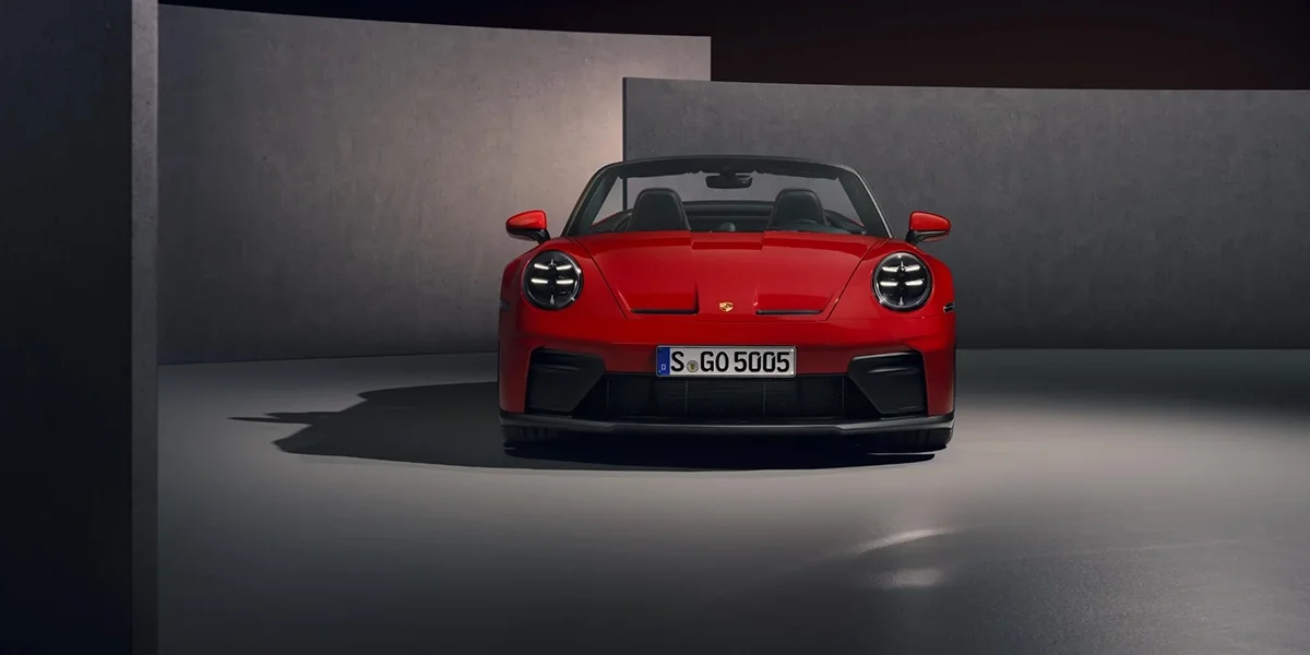 Front view of red Porsche 911 GT3 RS Cabriolet with LED headlights and aggressive styling.